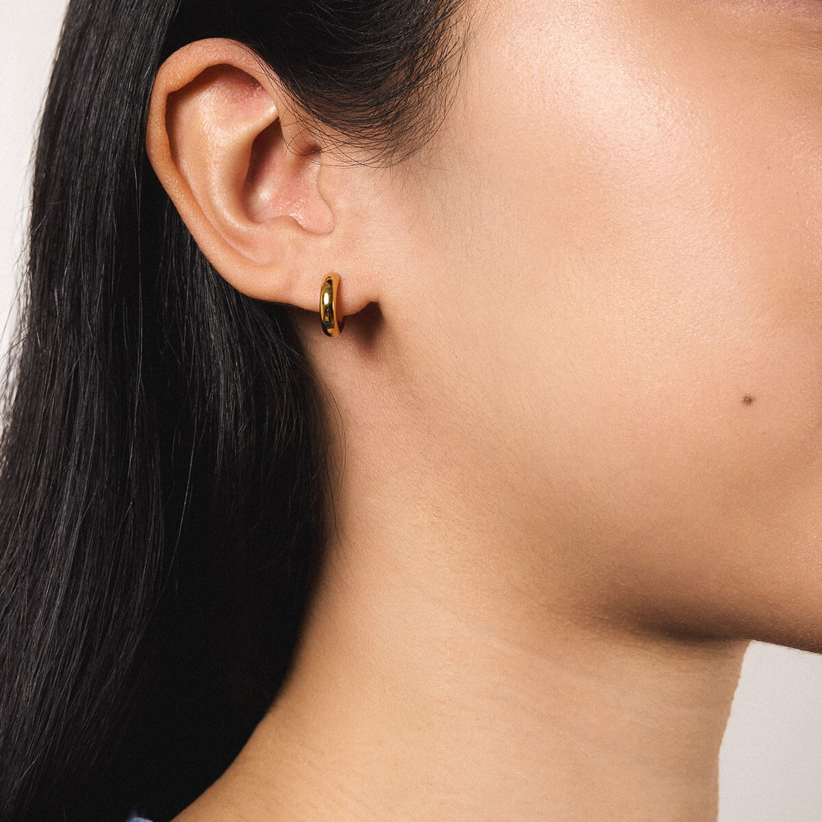 Bold Huggie Hoops in Titanium - Gold - On Model