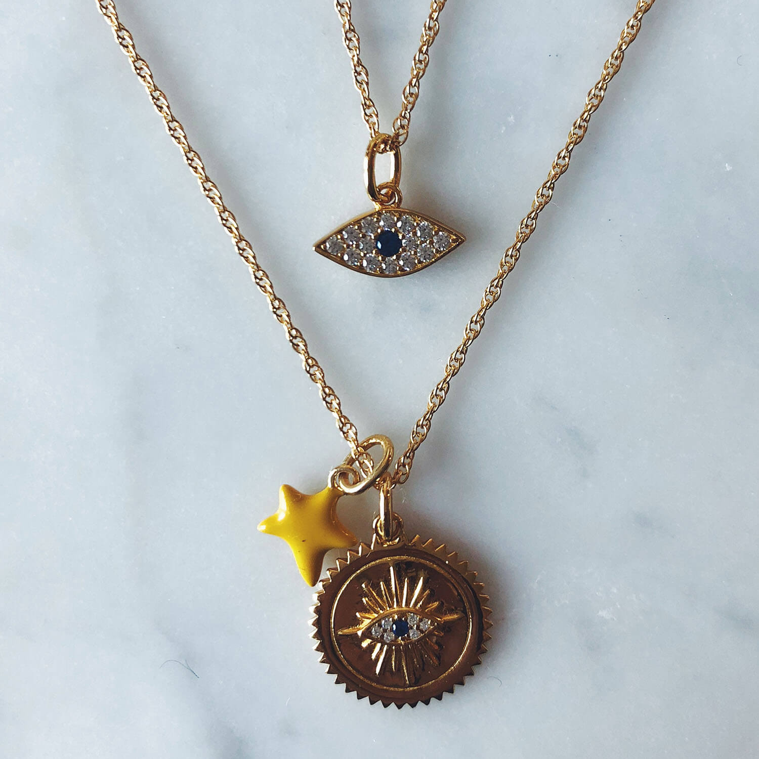 Evil Eye Charm in Gold Vermeil on table