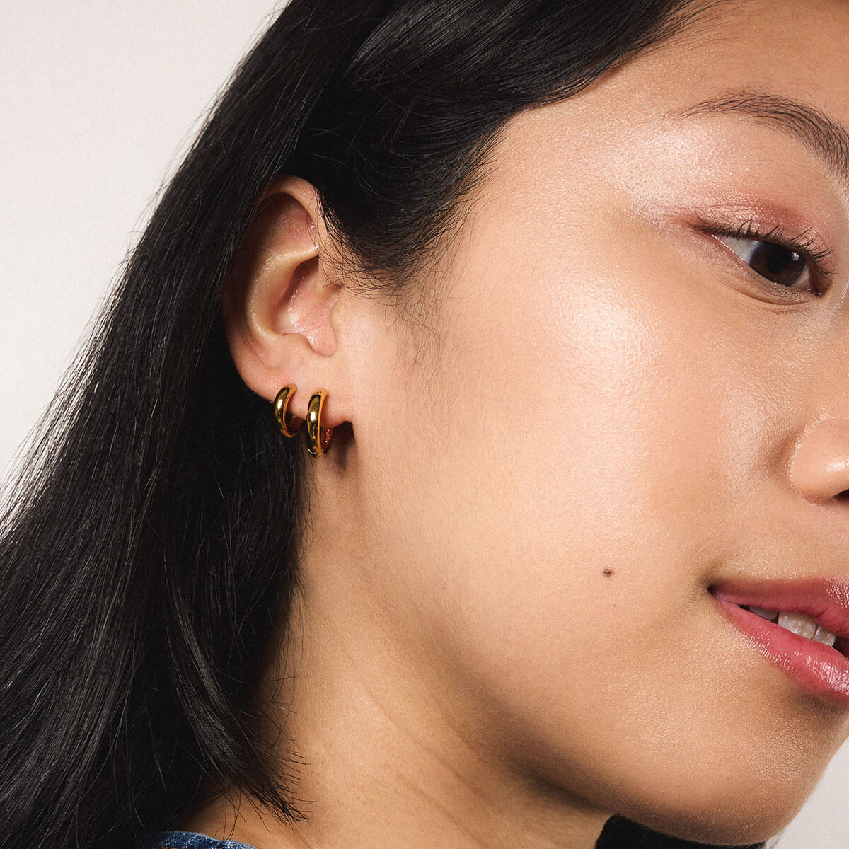 Bold Huggie Hoops in Titanium - Gold and Bold Hoops in Titanium - Gold (On Model)