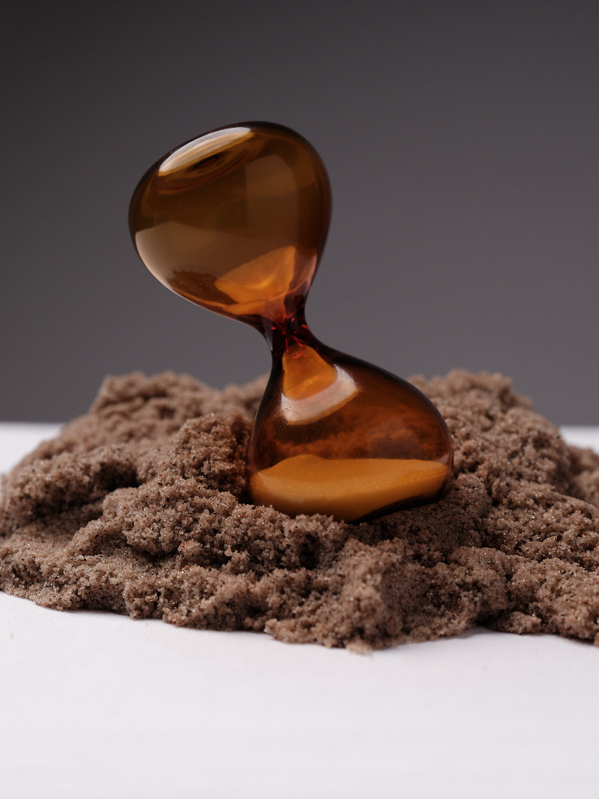 Amber five-minute hourglass in sand