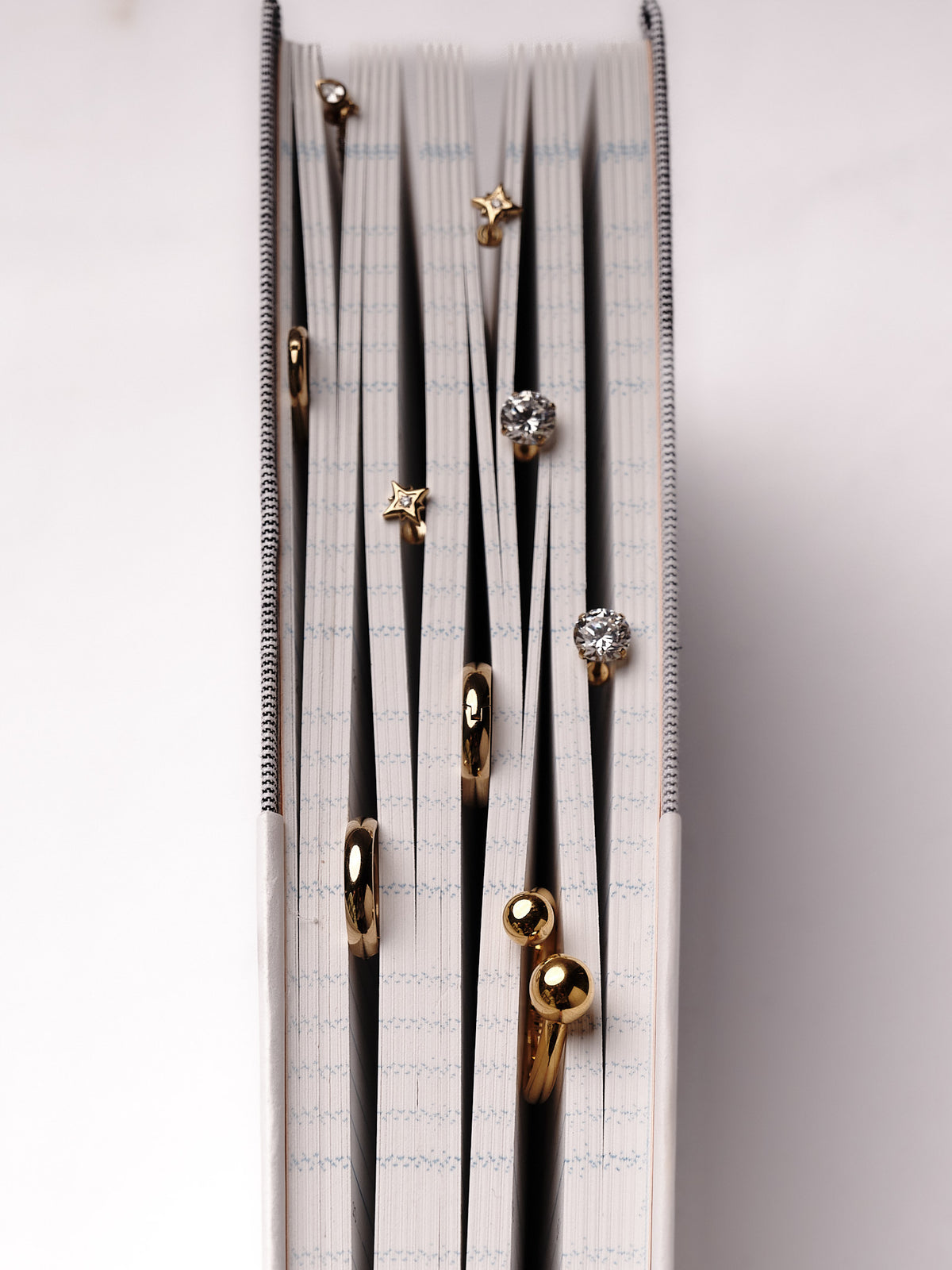 North Star earrings among jewelry in the pages of a journal