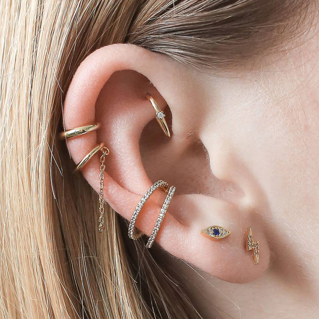 Evil eye and lightning nap earrings styled with ear cuffs and hoops