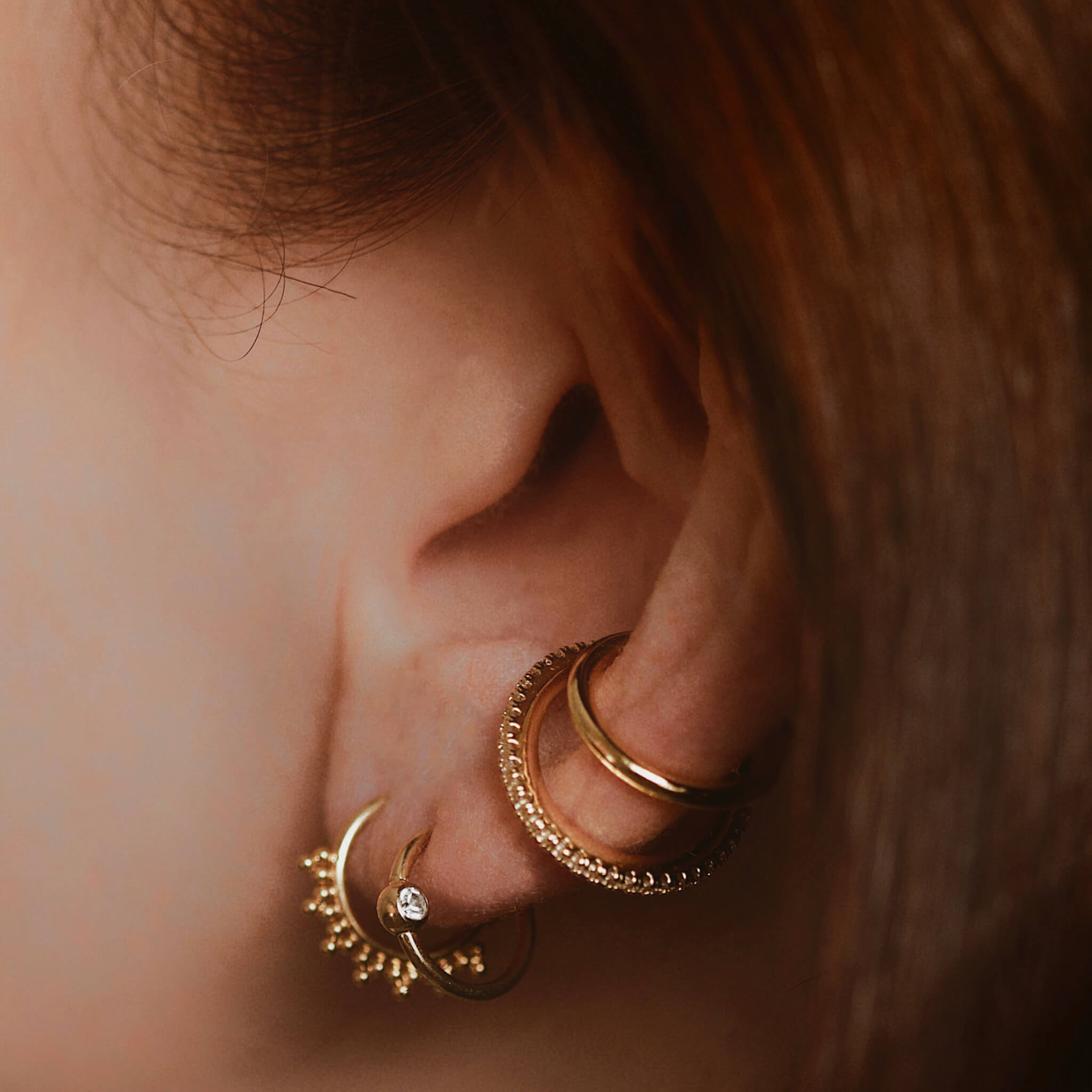 Orbital Crystal Cartilage Hoop on model (Titanium - Gold)