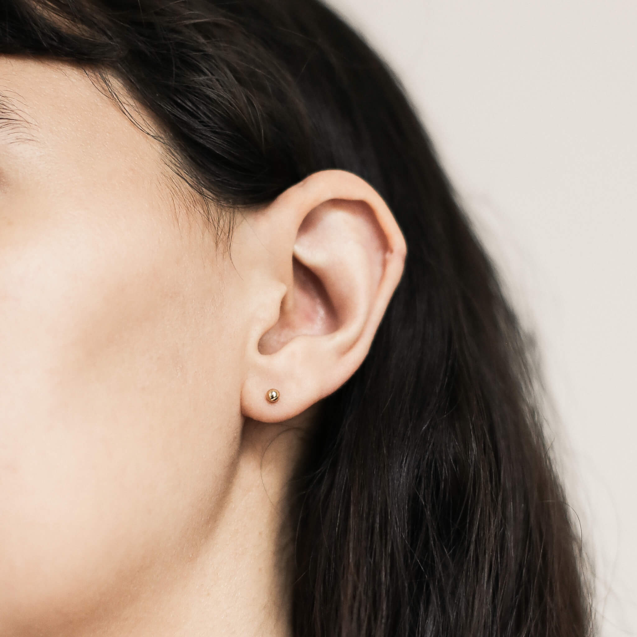 Little Sphere Studs in Titanium (Gold, 3mm) on model